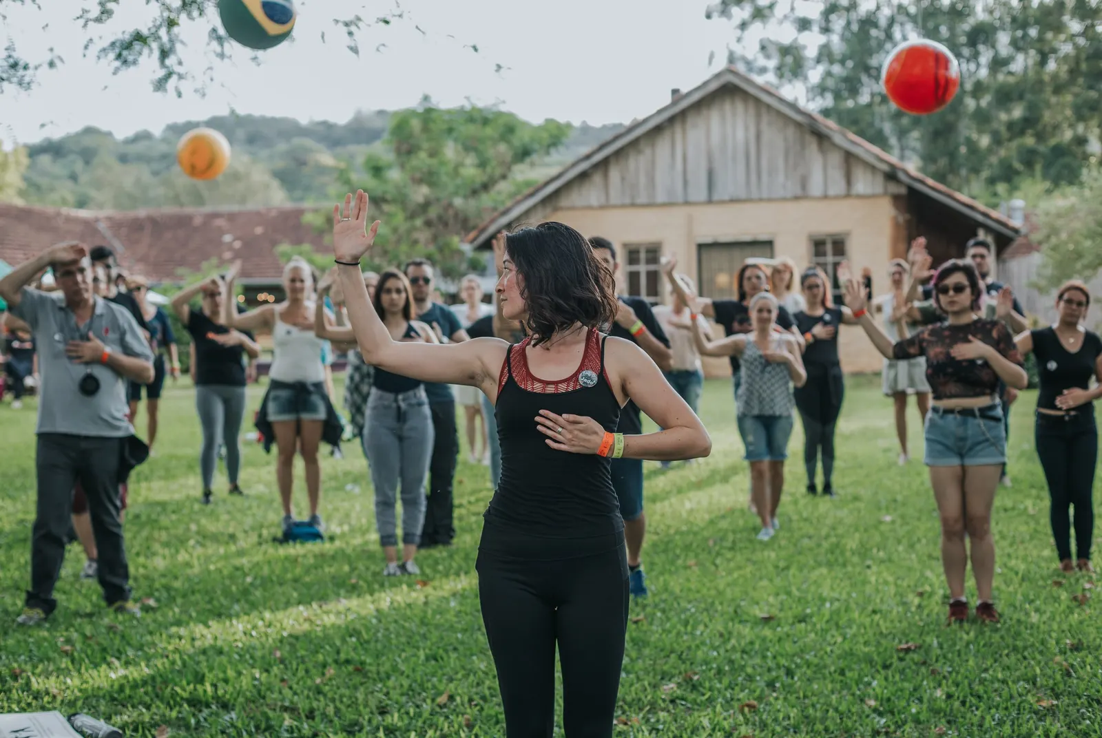 Participantes numa atividade com bolas no gramado do Sítio